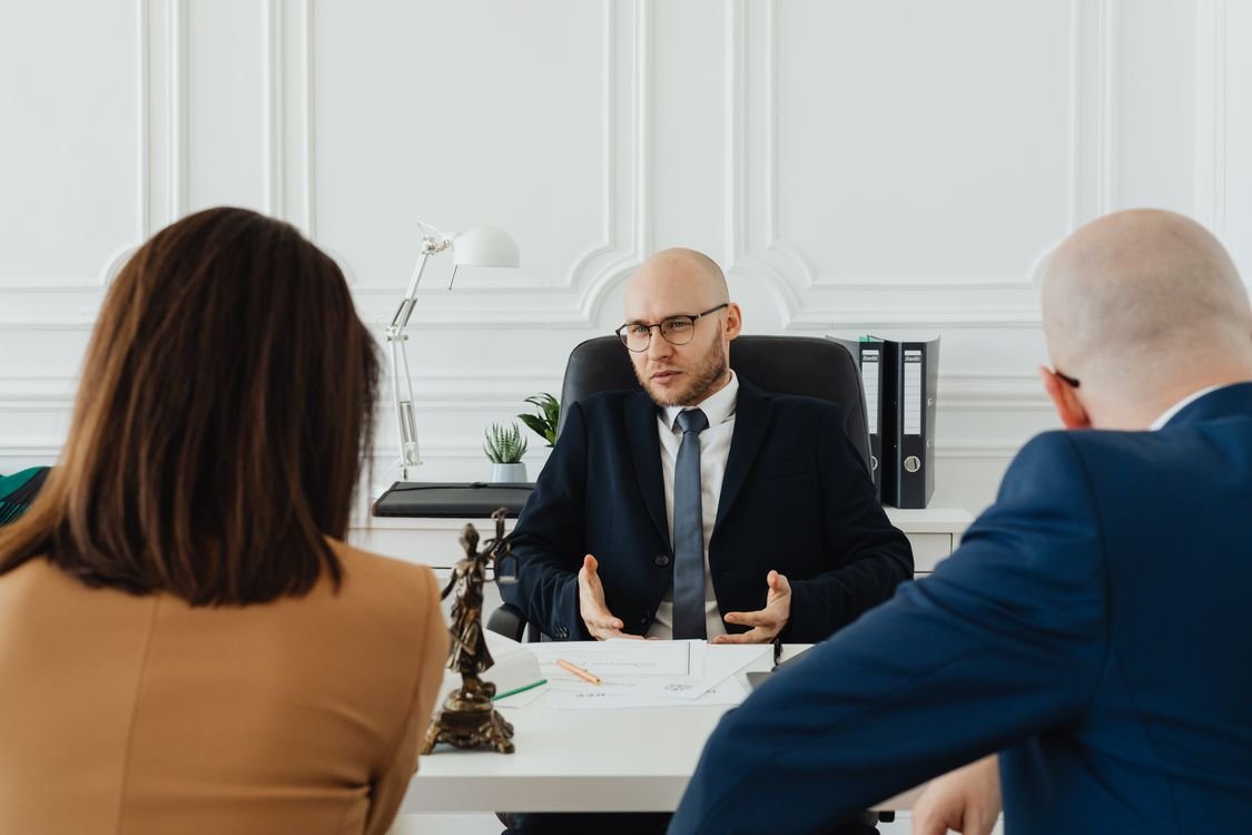 A professional in a one-to-one meeting at a desk, discussing their salary with a manager