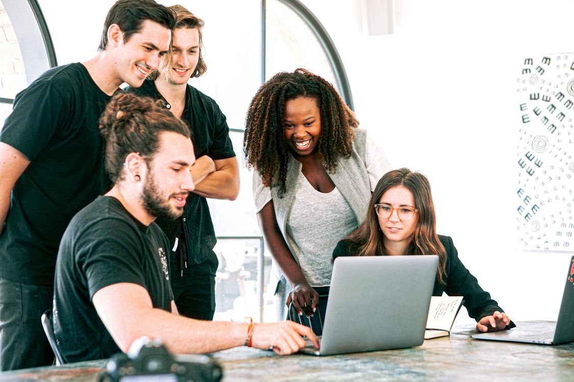 A group of professionals sitting around a table in a corporate meeting room, representing English training built for a company's employees