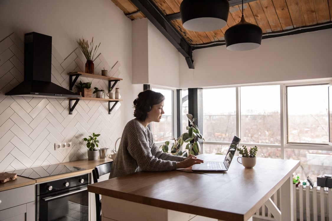 Eine Berufstätige mit Kopfhörern lernt online an ihrem Laptop Business-Englisch