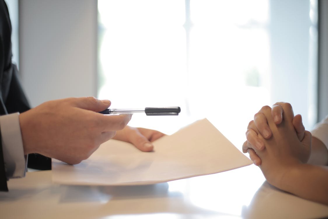 Business professional reviewing financial figures and price information on documents with a calculator