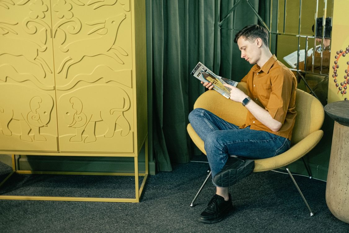 An adult English learner sitting and absorbed in reading, putting in the study hours needed to move up a CEFR level