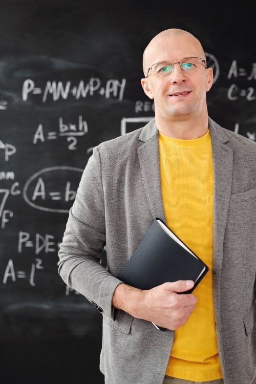 An IELTS candidate at a desk with a laptop and an exam answer sheet, choosing between the computer and paper test formats