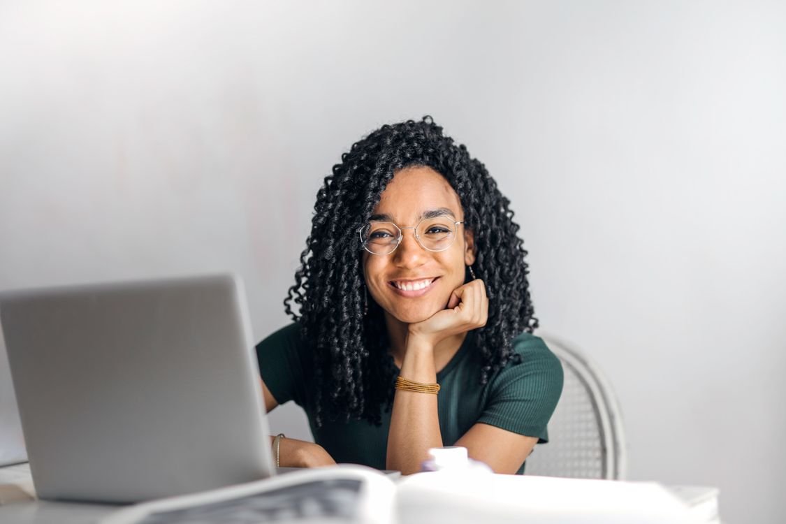 IELTS candidate at a desk comparing study materials and an exam answer sheet