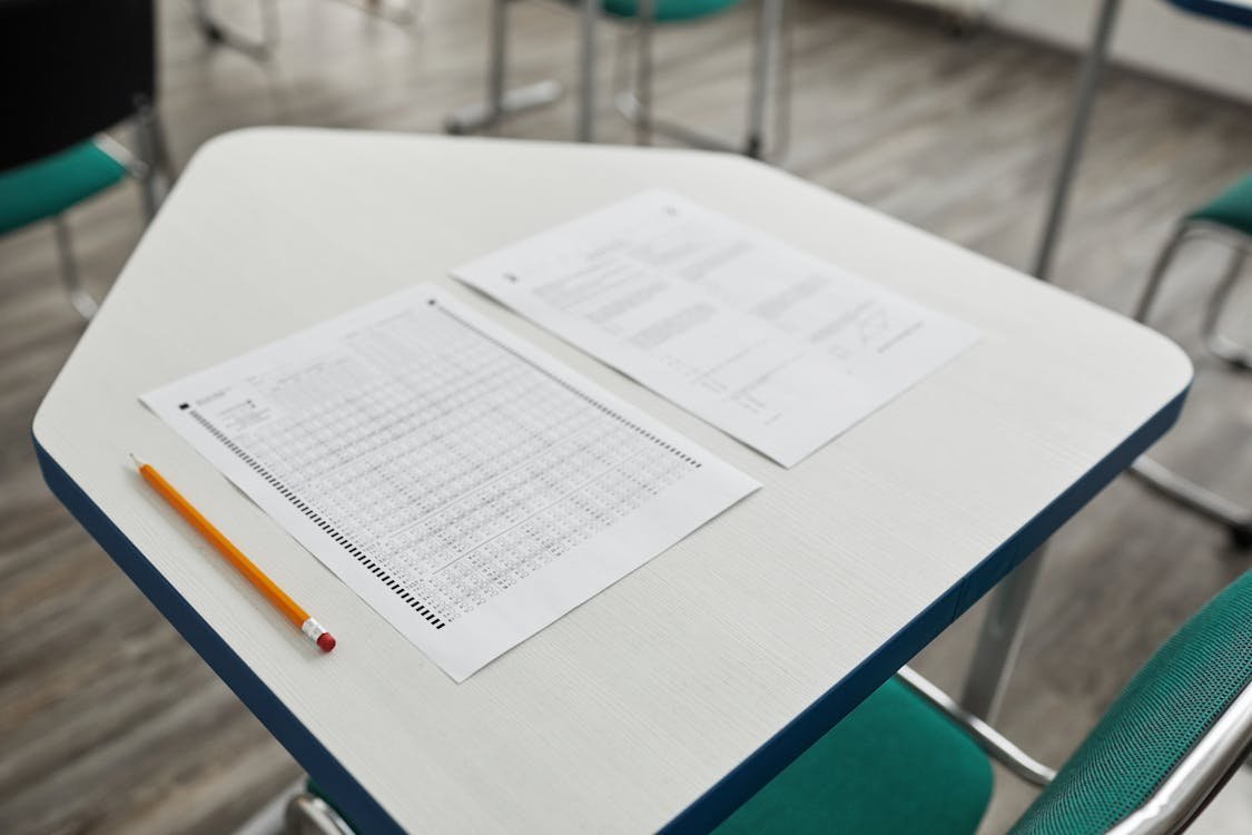 IELTS candidate wearing headphones and taking notes during a focused listening practice session
