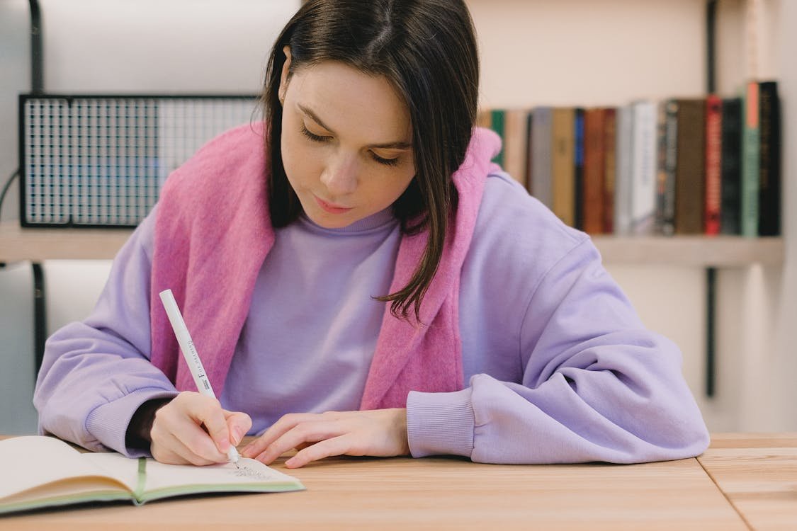 A focused English learner practising independently with notes at a quiet desk