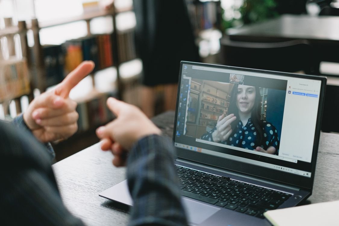 A learner speaking English on a video call during an online one-to-one lesson